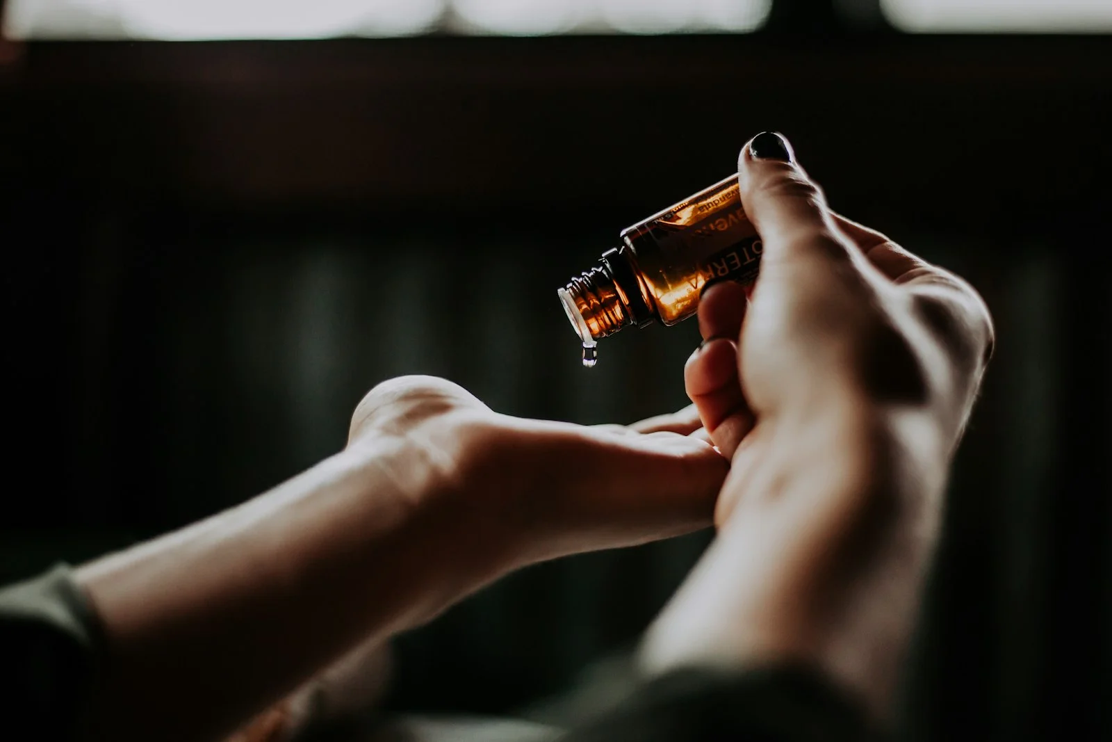 Goutte d’huile ambrée versée dans la main — lubrifiant lifestyle