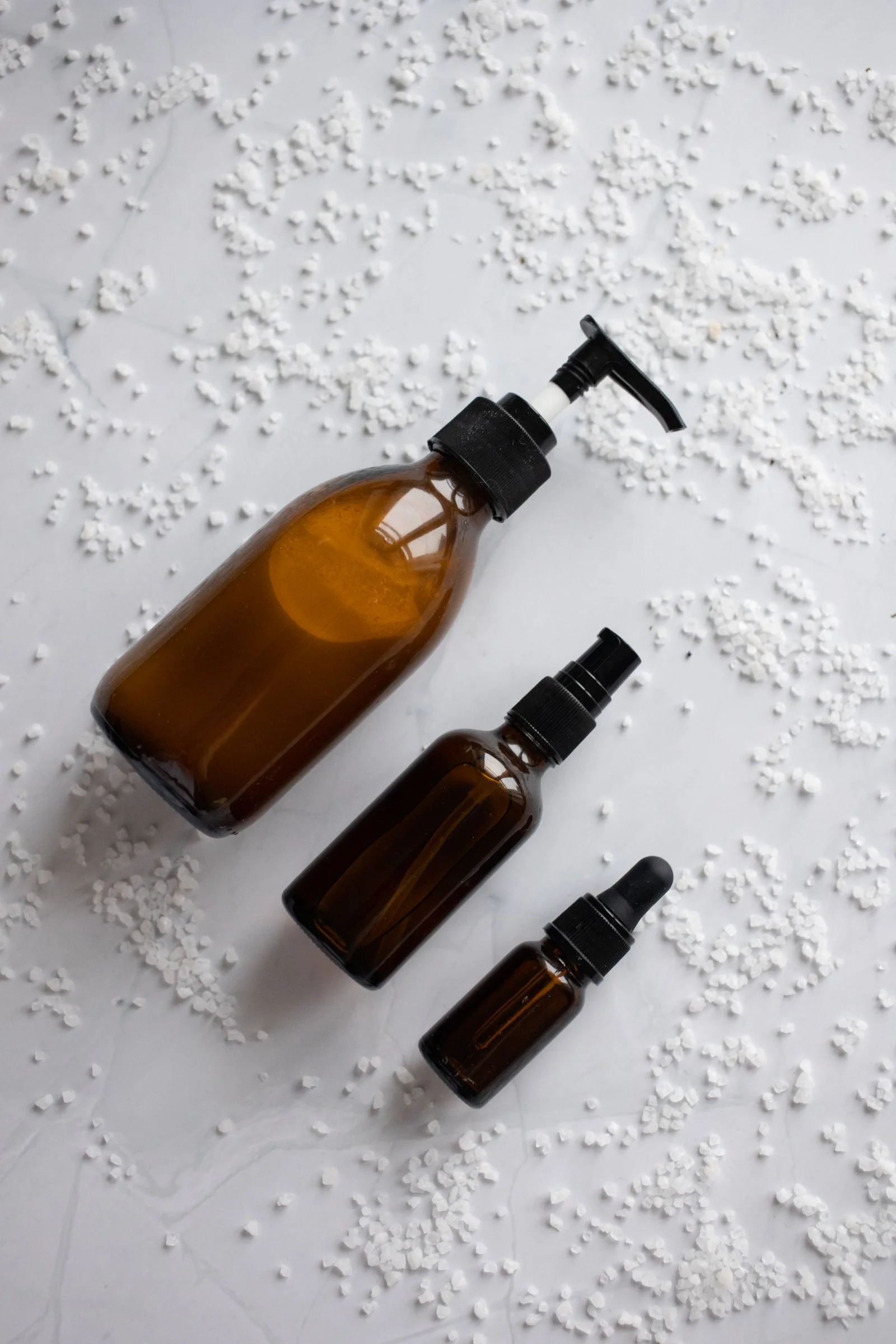 Flacons ambre et sels sur marbre — lubrifiant esthétique spa